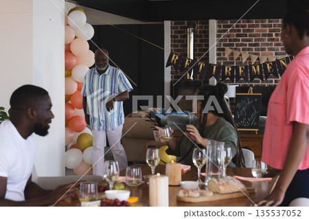 Celebrating retirement, family sharing food and drinks in joyful home gathering 135537052