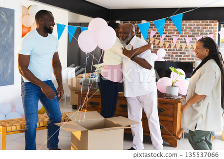 Family celebrating at home, hugging and smiling with balloons and decorations Family celebrating at home, hugging and smiling with balloons and decorations 135537066