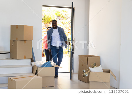 Couple entering new home with moving boxes, excited for fresh start 135537091