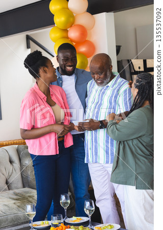 Family celebrating together at home, sharing joyful moments and laughter Family celebrating together at home, sharing joyful moments and laughter 135537092