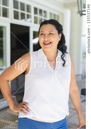 Smiling woman enjoying sunny day on porch, feeling relaxed and happy 135537146