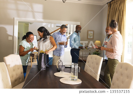 Seniors celebrating at home, enjoying wine and laughter with friends Seniors celebrating at home, enjoying wine and laughter with friends 135537155