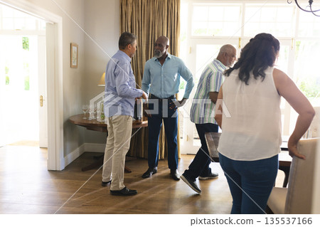 Seniors celebrating together at home, engaging in lively conversation and laughter 135537166