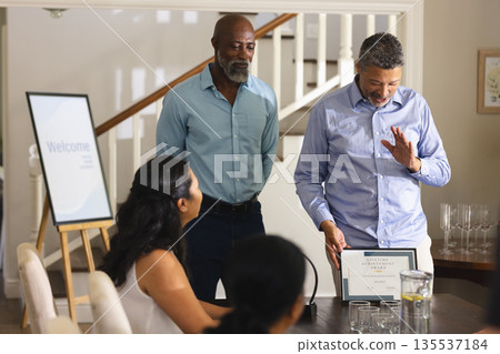 Receiving lifetime achievement award, man celebrating with friends at home, smiling Receiving lifetime achievement award, man celebrating with friends at home, smiling 135537184
