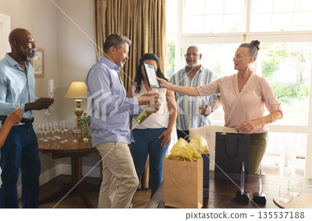 Celebrating at home, friends exchanging gifts and sharing joyful moments together 135537188