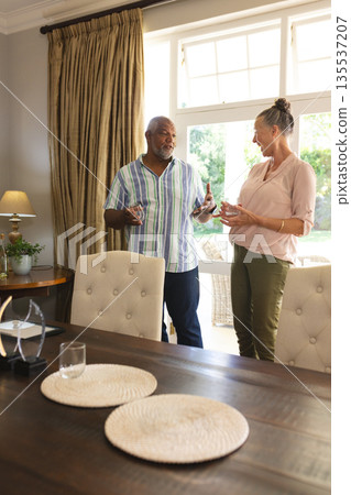 Senior couple enjoying conversation in bright living room, sharing joyful moments 135537207