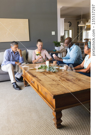 Seniors enjoying coffee and conversation at home, sharing joyful moments together 135537297