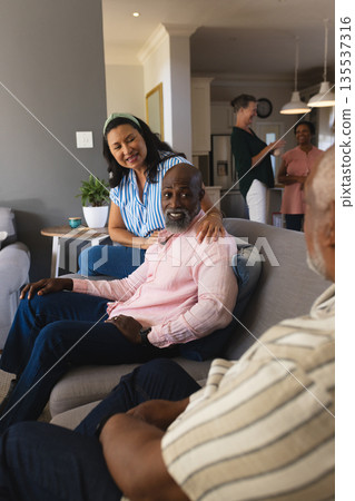 Family gathering in living room, seniors enjoying conversation and laughter together Family gathering in living room, seniors enjoying conversation and laughter together 135537316