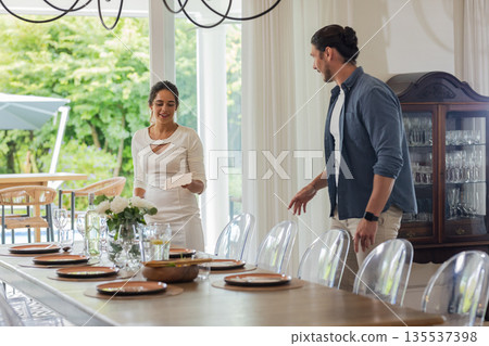 Preparing elegant dining table for wedding, couple smiling and arranging plates Preparing elegant dining table for wedding, couple smiling and arranging plates 135537398