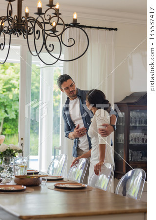 Couple sharing tender moment in elegant dining room before wedding celebration Couple sharing tender moment in elegant dining room before wedding celebration 135537417