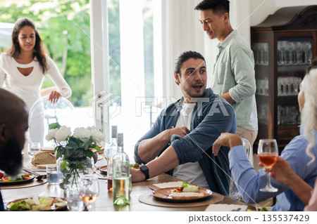 Friends enjoying lively conversation and delicious meal at elegant wedding reception Friends enjoying lively conversation and delicious meal at elegant wedding reception 135537429