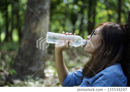Young Woman Drinking Water bottle outdoor park traveler. Asian female drinking water bottle healthy person happy smile. Happiness Beautiful asian chinese women holding mineral water bottle lifestyle Young Woman Drinking Water bottle outdoor park traveler. Asian female drinking water bottle healthy person happy smile. Happiness Beautiful asian chinese women holding mineral water bottle lifestyle 135538297