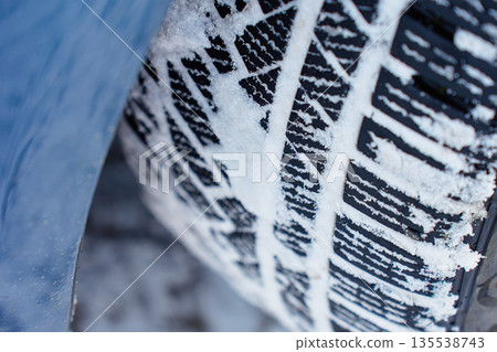 Winter tire tread pattern covered with snow close up Winter tire tread pattern covered with snow close up 135538743