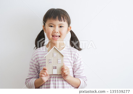 Child holding a model house (Mortgage, Children's room) 135539277