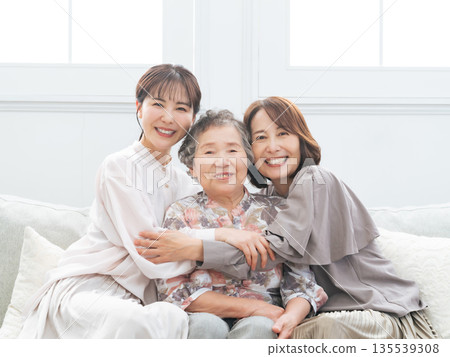Three generations of women smiling and standing close together Three generations of women smiling and standing close together 135539308