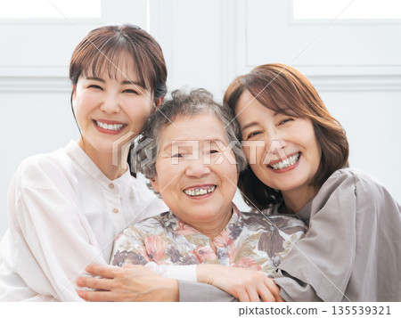 Three generations of women smiling and standing close together Three generations of women smiling and standing close together 135539321