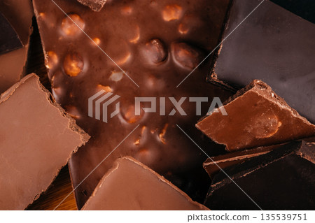 Dark and milk chocolate pieces texture background, close-up Dark and milk chocolate pieces texture background, close-up 135539751