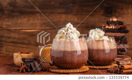 Two glasses of hot chocolate with whipped cream on rustic wooden background Two glasses of hot chocolate with whipped cream on rustic wooden background 135539774