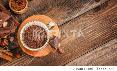 Hot chocolate topped with chocolate shavings in ceramic cup on wooden background, top view Hot chocolate topped with chocolate shavings in ceramic cup on wooden background, top view 135539782