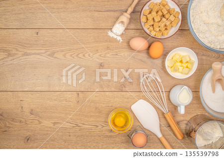 Baking ingredients with eggs butter sugar and flour arranged on wooden table with copy space 135539798