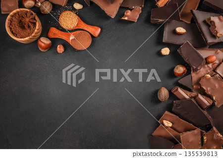 Chocolate pieces with cocoa powder and spices on dark background with copy space 135539813