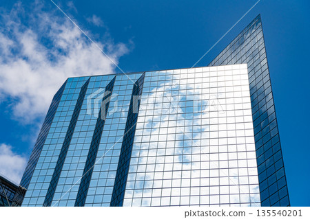 Business skyscraper with reflection. Modern glass building. Skyscraper in city downtown. City downtown with skyscraper. Office building in business district. Skyscraper building architecture Business skyscraper with reflection. Modern glass building. Skyscraper in city downtown. City downtown with skyscraper. Office building in business district. Skyscraper building architecture 135540201