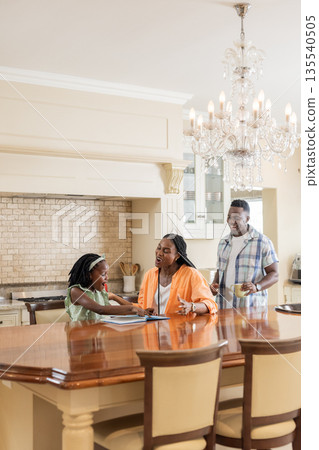 African American family at kitchen table, sharing joyful conversation and moments 135540505