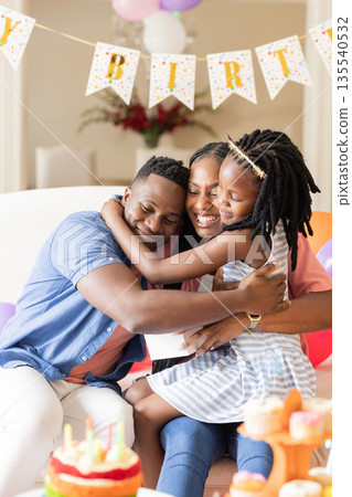 Celebrating birthday, African American family hugging with cake and decorations Celebrating birthday, African American family hugging with cake and decorations 135540532