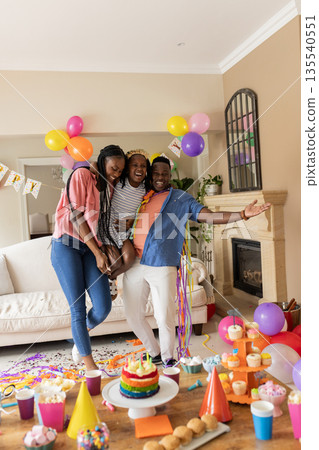 Celebrating birthday, family with child posing with colorful decorations at home Celebrating birthday, family with child posing with colorful decorations at home 135540551