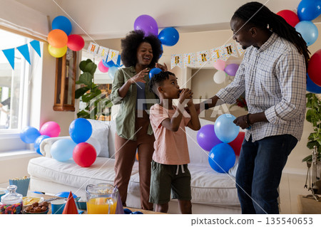 Celebrating child's birthday, African American family with balloons and decorations at home 135540653