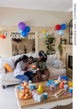 Celebrating birthday, African American family enjoying cake and decorations at home Celebrating birthday, African American family enjoying cake and decorations at home 135540666