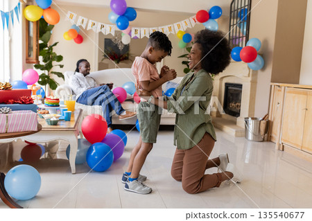 Celebrating birthday, joyful family enjoying party with colorful balloons at home Celebrating birthday, joyful family enjoying party with colorful balloons at home 135540677