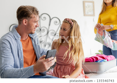 Father and daughter packing suitcase at home, preparing for family trip Father and daughter packing suitcase at home, preparing for family trip 135540743