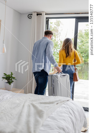 Couple leaving home with suitcase, preparing for travel adventure together Couple leaving home with suitcase, preparing for travel adventure together 135540777