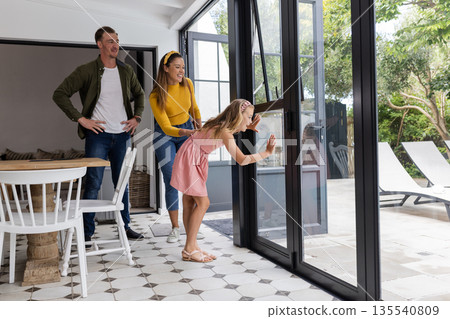 Opening patio doors to backyard, family feeling excited and happy on sunny day 135540809