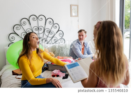 Family enjoying playful moment at home, woman surprised by child's story 135540810