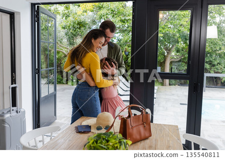 Family embracing warmly by poolside patio, enjoying quality time together at home 135540811