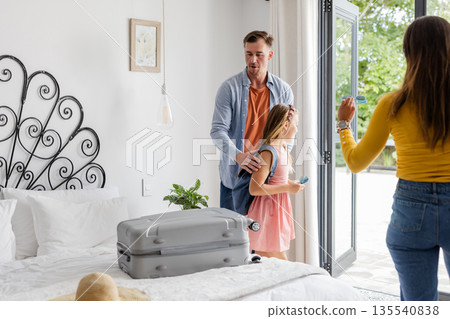 Family arriving at hotel room, unpacking suitcase, enjoying vacation together 135540838