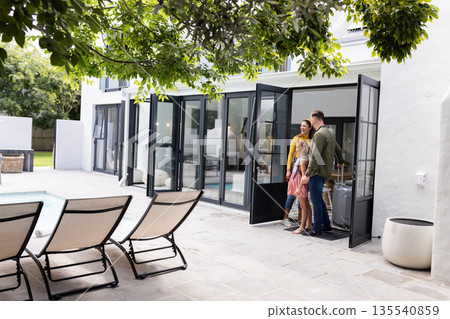Happy family stepping outside to enjoy sunny day by poolside patio Happy family stepping outside to enjoy sunny day by poolside patio 135540859