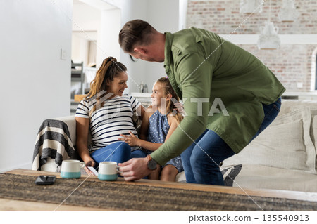 Family enjoying quality time together on couch, smiling and bonding at home 135540913