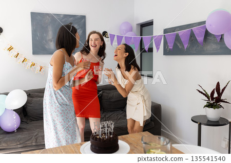 Laughing and celebrating, three young women enjoy birthday party at home Laughing and celebrating, three young women enjoy birthday party at home 135541540