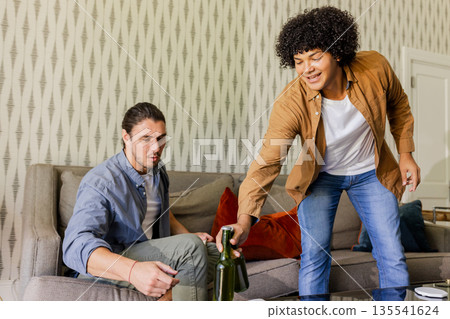 Friends enjoying drinks together at home, sharing laughter and good times 135541624
