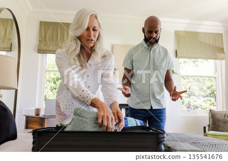 Couple packing suitcase in bedroom, preparing for wedding day celebration 135541676