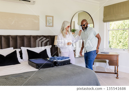 Couple packing suitcase in bedroom, preparing for wedding day celebration 135541686