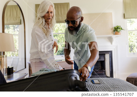 Couple packing suitcase together in cozy bedroom, preparing for wedding day 135541707