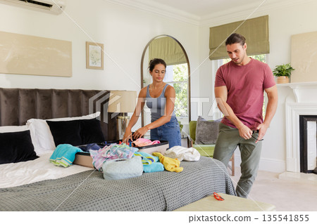 Couple packing suitcase in bedroom, preparing for wedding day celebration 135541855