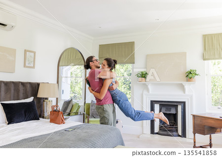Couple joyfully embracing in cozy bedroom, celebrating special moment together Couple joyfully embracing in cozy bedroom, celebrating special moment together 135541858