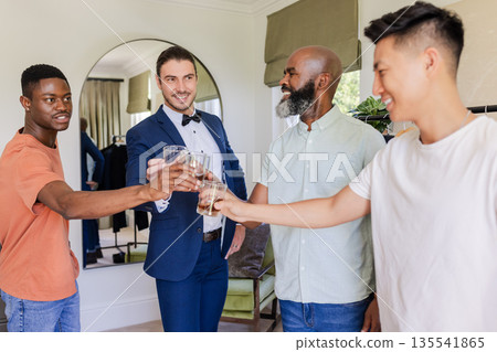 Friends toasting with drinks, celebrating groom's special day in stylish room Friends toasting with drinks, celebrating groom's special day in stylish room 135541865