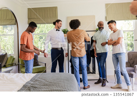 Groom and friends preparing outfits, sharing laughter and excitement at home 135541867