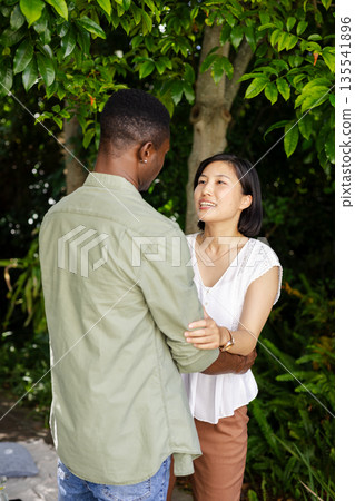 Under lush greenery, couple embracing and sharing joyful moment together 135541896